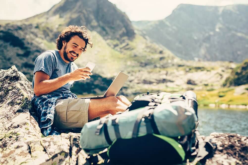 Jobba som digital nomad Man jobbar online från en fridfull plats