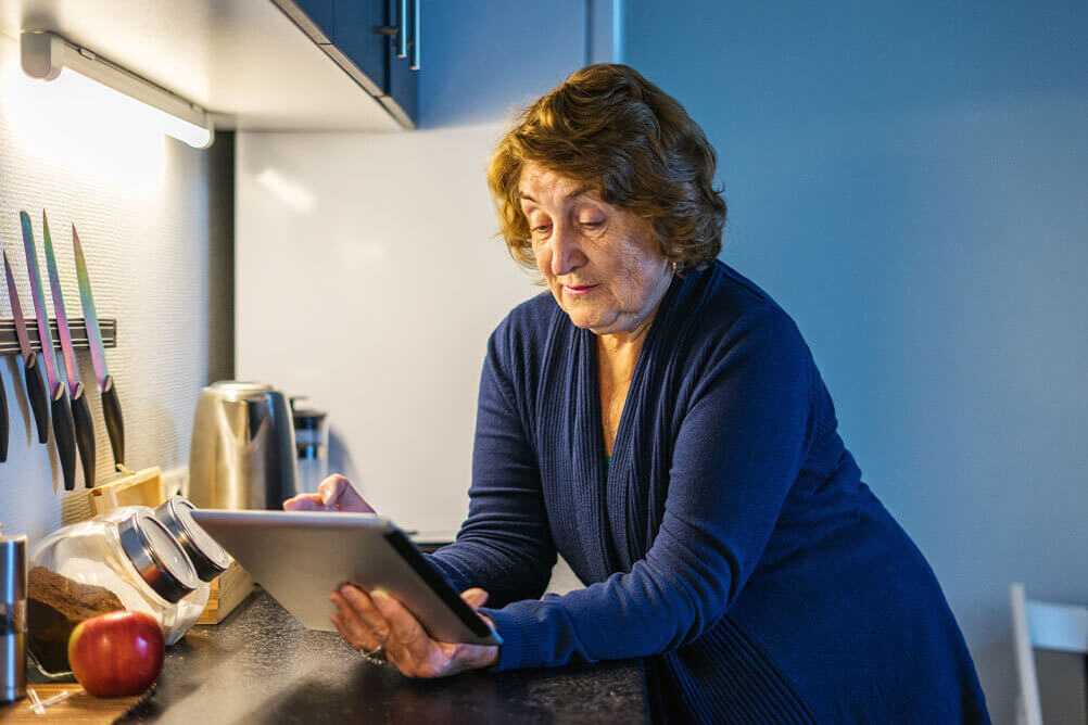 Kvinna i köket som spelar på lotto.